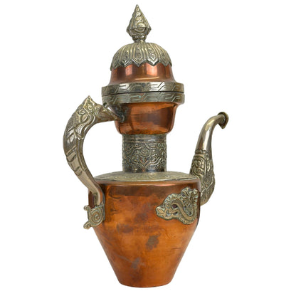 Schuin vooraanzicht van de koperen Tibetaanse theepot, tonend de gedetailleerde paktong handgreep in de vorm van een drakenschip.