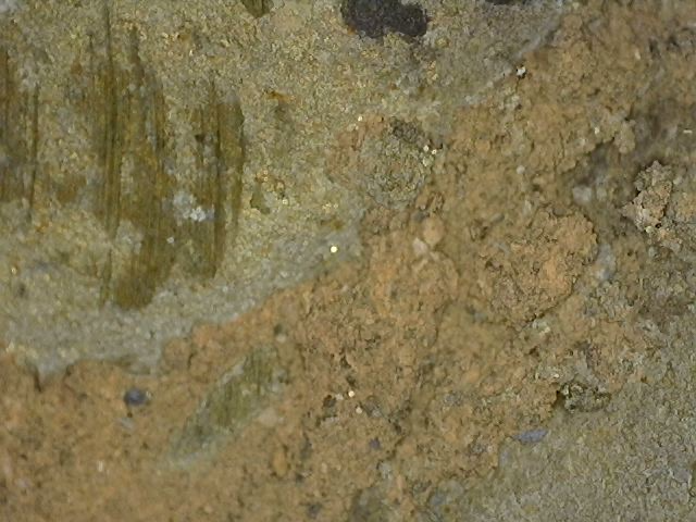 Microscopisch beeld van bladgoudfragmenten tussen cuprite-lagen op Khmer bronzen Vishnu borstbeeld