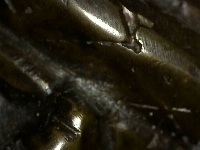 Detail van fragmentarische bladgoudresten ingebed in patina op Khmer bronzen Vishnu borstbeeld