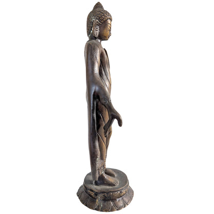 Zijaanzicht van de staande Boeddha figuur met vloeiende gewaden in brons.